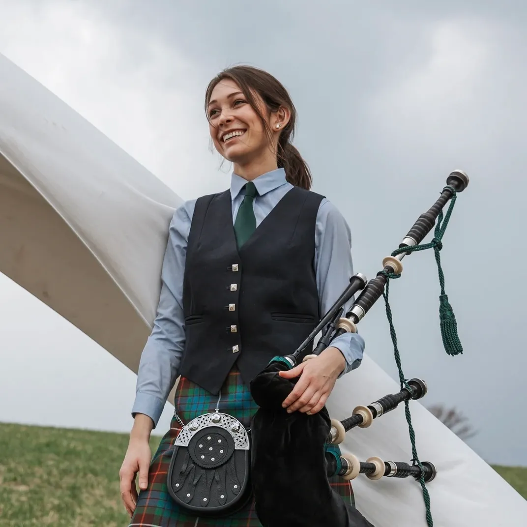 Colleen Curry, Highland bagpiper, standing in a field