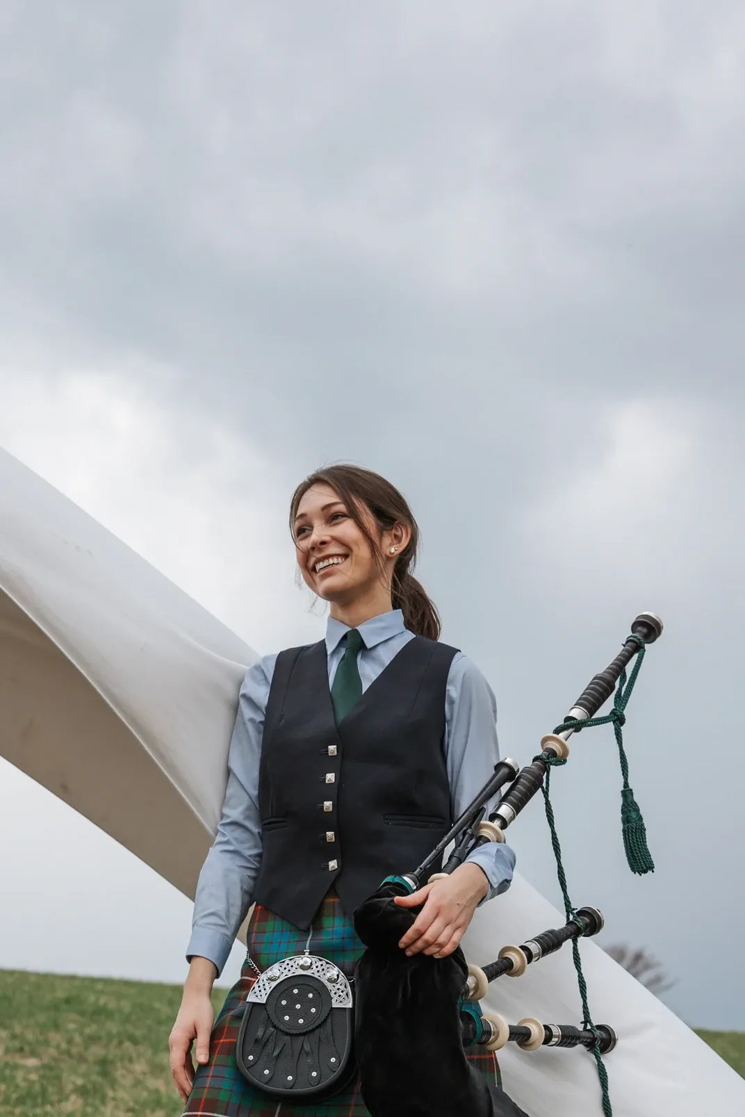Colleen Curry, Highland bagpiper, standing in a field